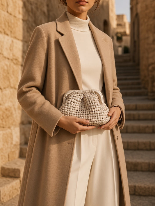 Model holding the Yazli Pouch Clutch in Cream handwoven leather